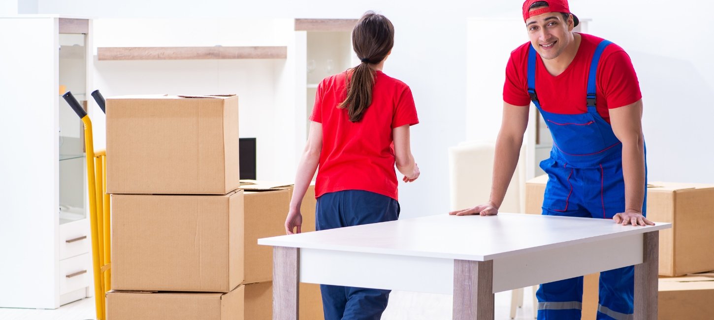 A happy family watching professional movers carrying boxes